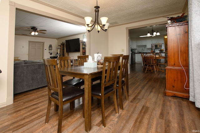 dining area with a textured ceiling, crown molding, dark hardwood / wood-style flooring, and ceiling fan with notable chandelier