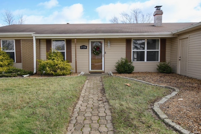 single story home featuring a front lawn