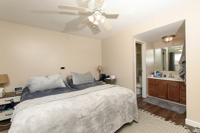 bedroom featuring dark hardwood / wood-style flooring, connected bathroom, ceiling fan, and sink