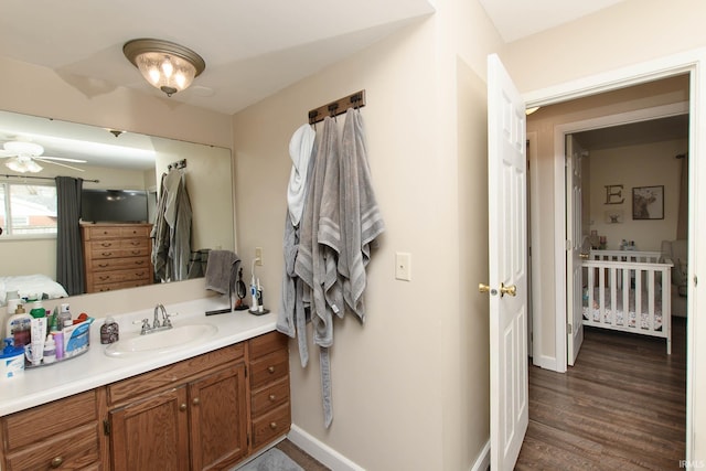 bathroom with ceiling fan, vanity, and wood-type flooring