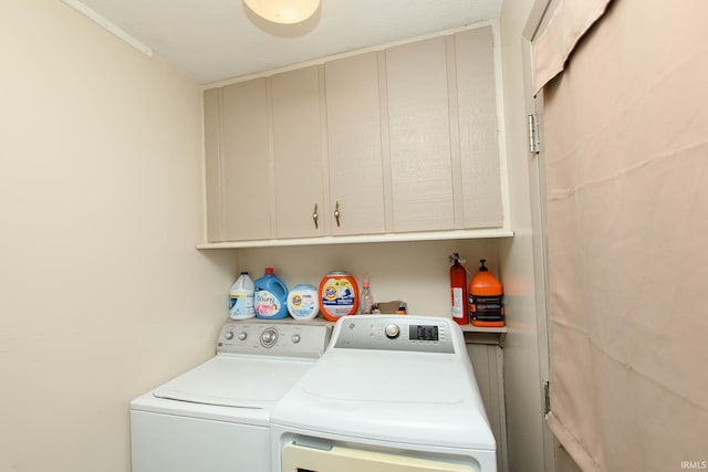 laundry room with washing machine and clothes dryer and cabinets