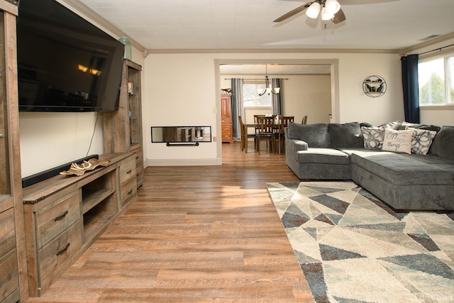 living room featuring hardwood / wood-style flooring, ceiling fan, and ornamental molding