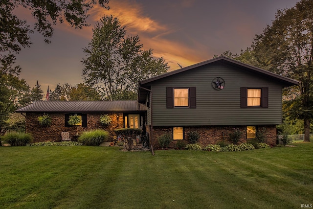 back house at dusk featuring a yard