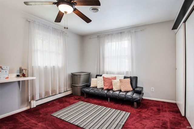 living area featuring carpet floors, ceiling fan, and a baseboard heating unit