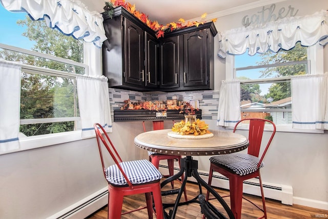 dining space with light hardwood / wood-style floors, plenty of natural light, baseboard heating, and ornamental molding