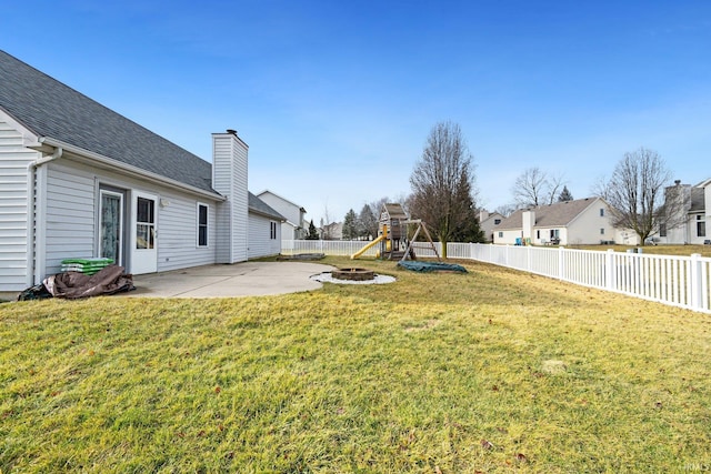 view of yard featuring a fire pit, a playground, and a patio