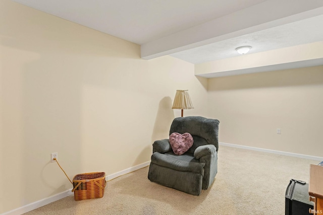 sitting room with carpet flooring and beam ceiling