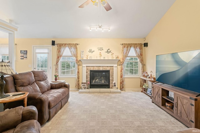 carpeted living room with a wealth of natural light, a fireplace, and ceiling fan