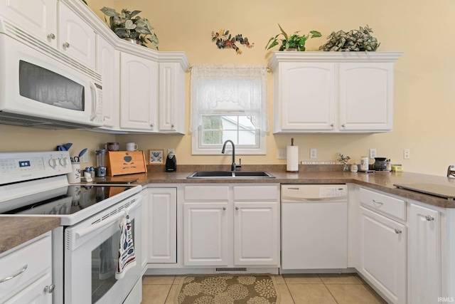 kitchen with light tile patterned floors, white appliances, white cabinetry, and sink