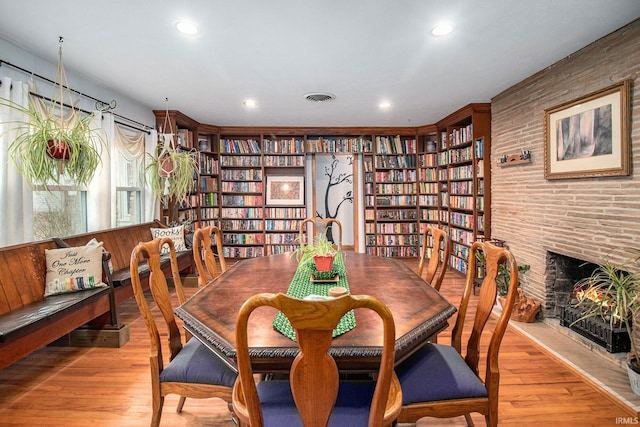 dining space with a fireplace and light hardwood / wood-style floors