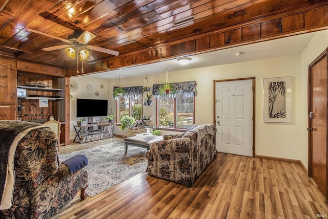 living room with ceiling fan, light hardwood / wood-style floors, and wood ceiling