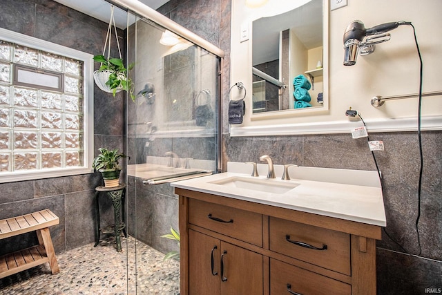 bathroom with vanity, walk in shower, and tile walls