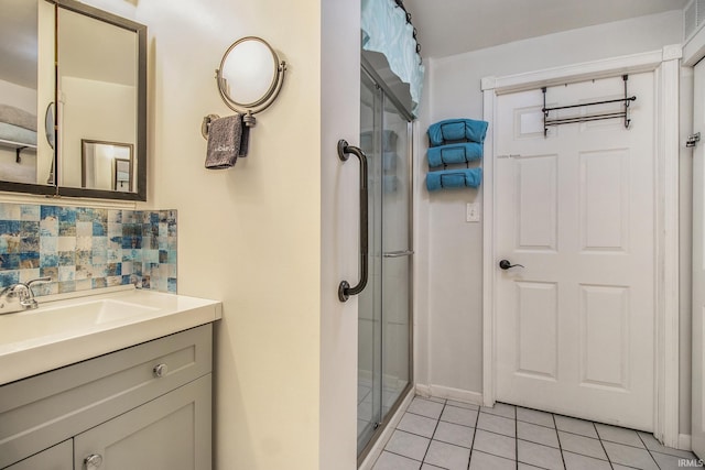 bathroom with vanity, tasteful backsplash, tile patterned floors, and a shower with shower door