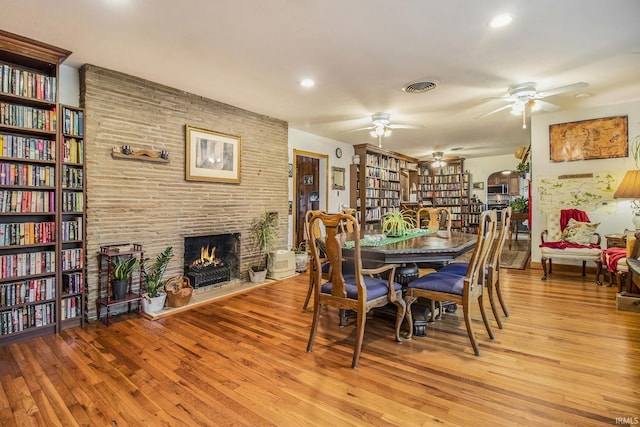 dining room with a fireplace and light wood-type flooring