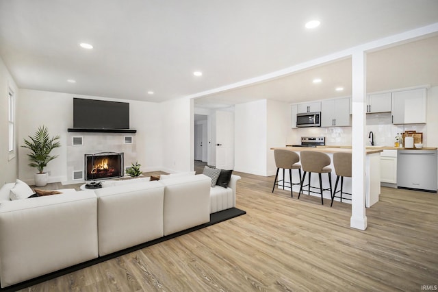 living room with sink and light wood-type flooring