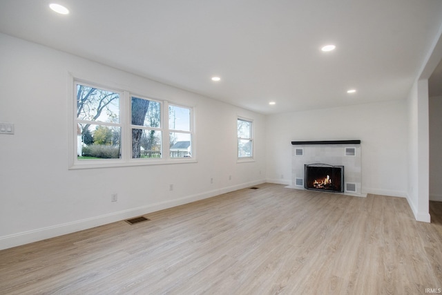 unfurnished living room with a fireplace and light hardwood / wood-style floors