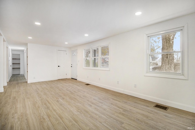 unfurnished room featuring a healthy amount of sunlight and light wood-type flooring