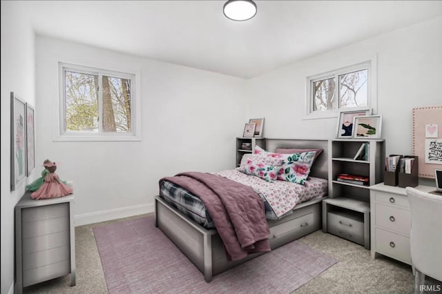 bedroom featuring light colored carpet and multiple windows