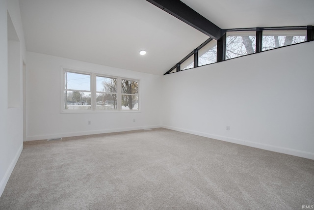 carpeted spare room featuring beam ceiling and high vaulted ceiling