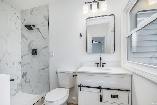 bathroom featuring vanity, toilet, and a tile shower