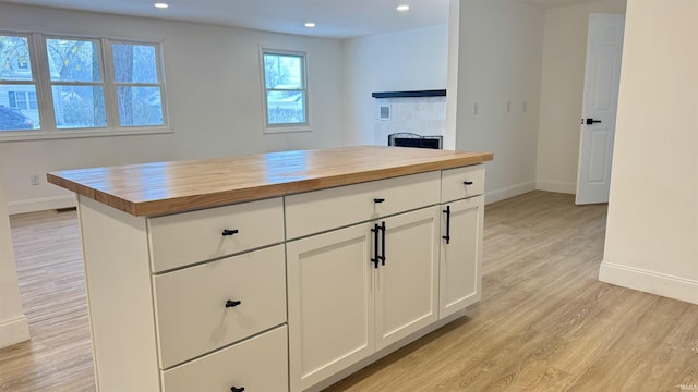 kitchen featuring white cabinets, wood counters, and light wood-type flooring