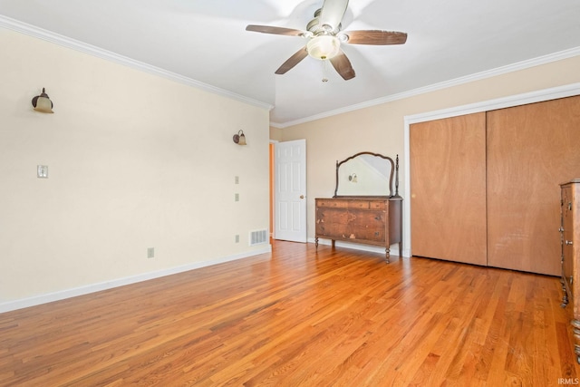 unfurnished bedroom featuring a closet, ceiling fan, crown molding, and light hardwood / wood-style flooring