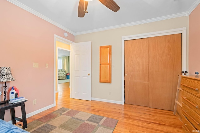 bedroom with light wood-type flooring, a closet, ornamental molding, and ceiling fan