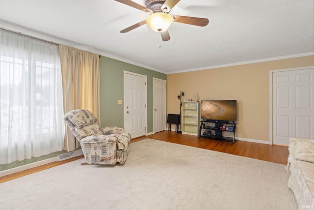 sitting room featuring ornamental molding, hardwood / wood-style flooring, ceiling fan, and a healthy amount of sunlight