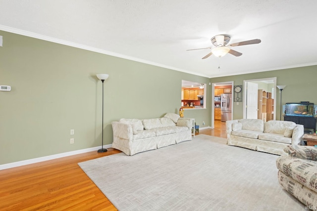 living room featuring ceiling fan, crown molding, and hardwood / wood-style flooring