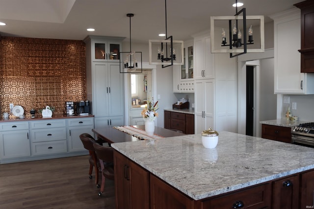 kitchen featuring white cabinets, pendant lighting, and dark brown cabinetry