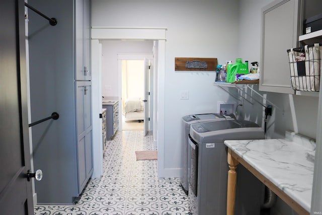 laundry area with separate washer and dryer and cabinets