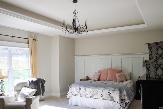 bedroom featuring a tray ceiling, carpet flooring, and a chandelier