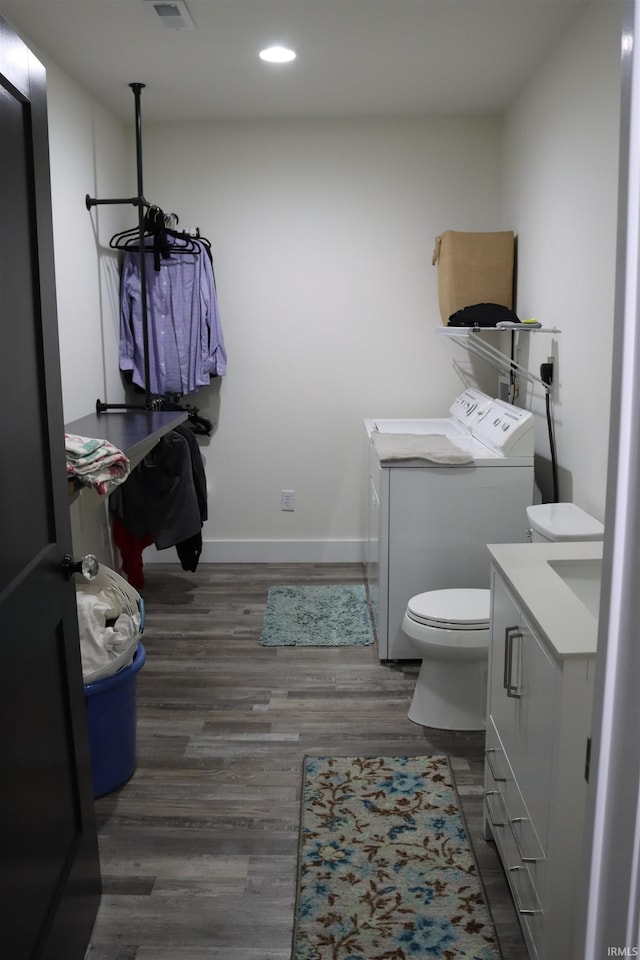 bathroom featuring separate washer and dryer, hardwood / wood-style floors, vanity, and toilet