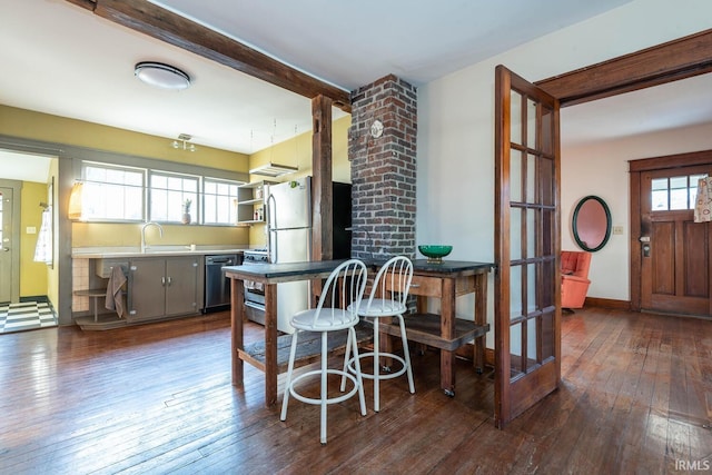 kitchen featuring beam ceiling, gray cabinetry, sink, dark wood-type flooring, and stainless steel appliances