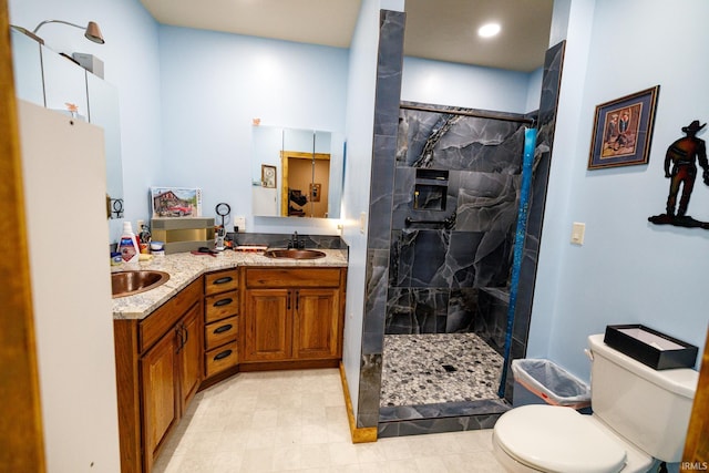 bathroom featuring tiled shower, vanity, and toilet