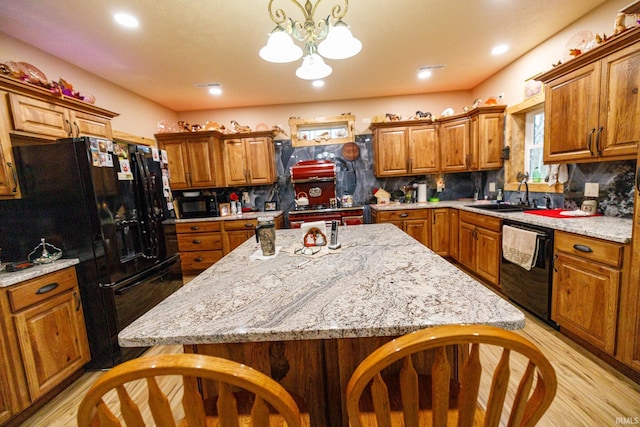 kitchen featuring black appliances, pendant lighting, light stone countertops, and tasteful backsplash