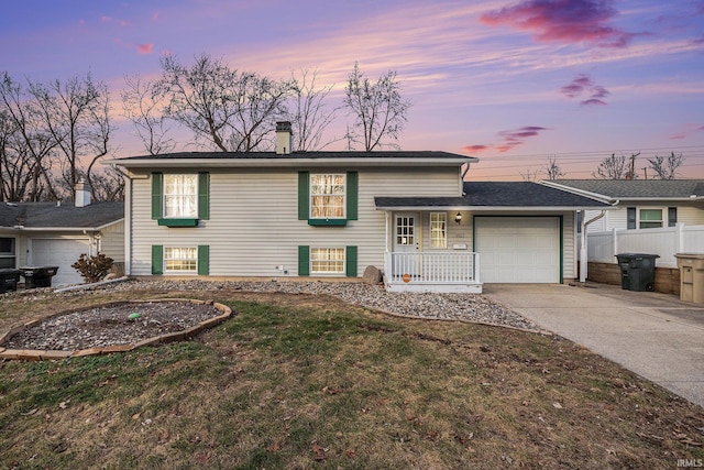 view of front of home with a yard, a porch, and a garage