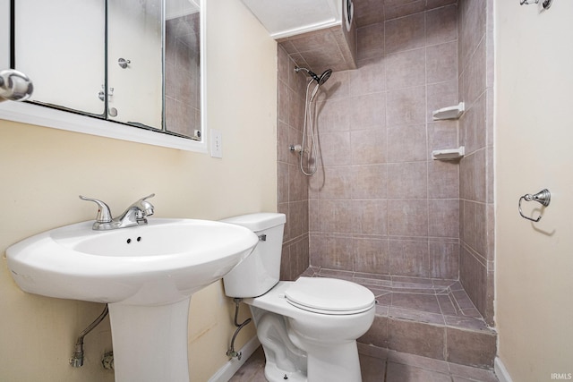 bathroom featuring a tile shower and toilet