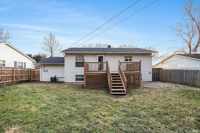 rear view of house featuring a lawn, cooling unit, and a wooden deck