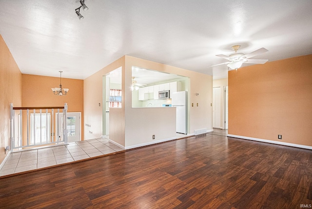 unfurnished living room with wood-type flooring and ceiling fan with notable chandelier