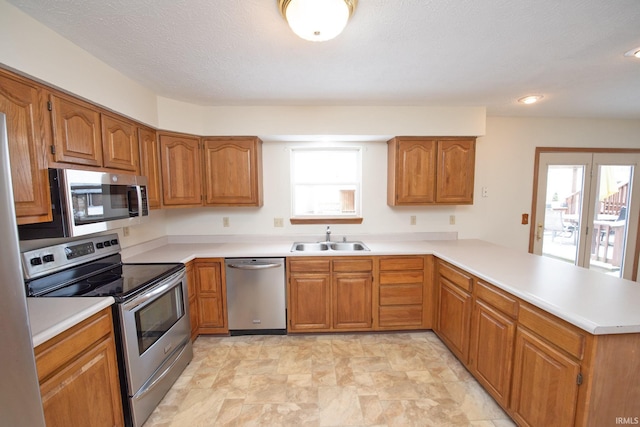 kitchen featuring kitchen peninsula, stainless steel appliances, a wealth of natural light, and sink