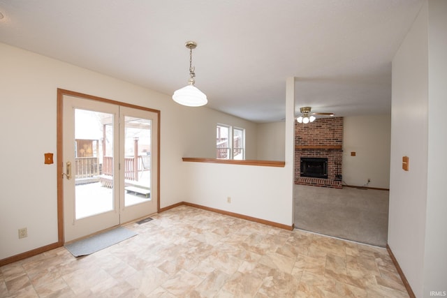 interior space featuring ceiling fan, a fireplace, and light colored carpet