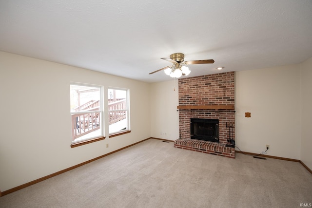 unfurnished living room with light carpet, ceiling fan, and a brick fireplace