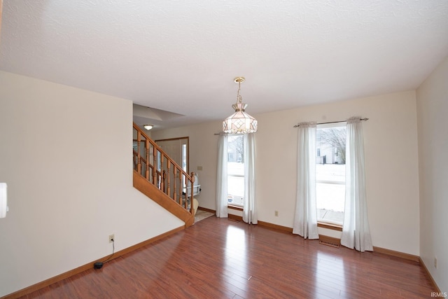 spare room featuring a textured ceiling and dark wood-type flooring