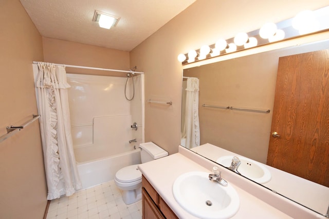 full bathroom featuring shower / bath combo with shower curtain, vanity, a textured ceiling, and toilet