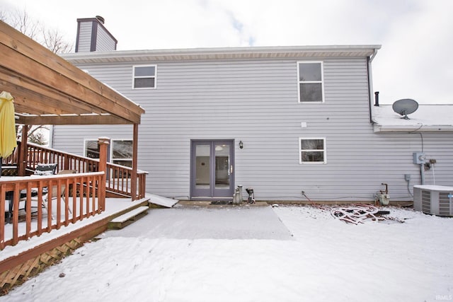 snow covered property featuring a pergola, a wooden deck, and central AC