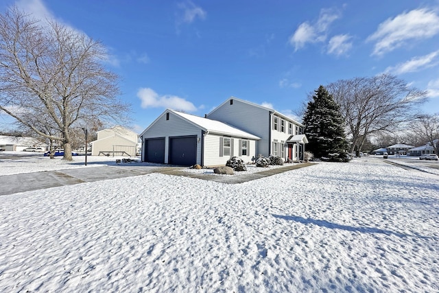 snow covered property with a garage