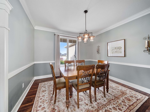 dining area with dark hardwood / wood-style floors, ornamental molding, and an inviting chandelier