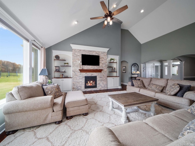 living room with decorative columns, built in shelves, a healthy amount of sunlight, and wood-type flooring