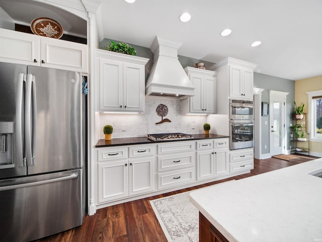 kitchen with white cabinets, premium range hood, stainless steel appliances, and dark wood-type flooring